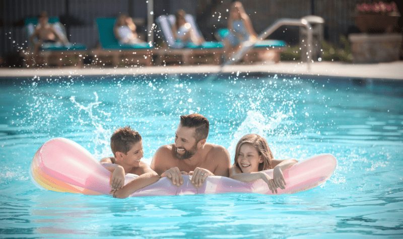 man and his two kids in the pool